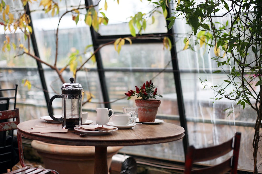 窓辺に植物を配した、木の一枚板テーブルの土間席