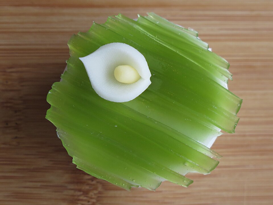 抹茶色の生地に白い花をあしらった和菓子